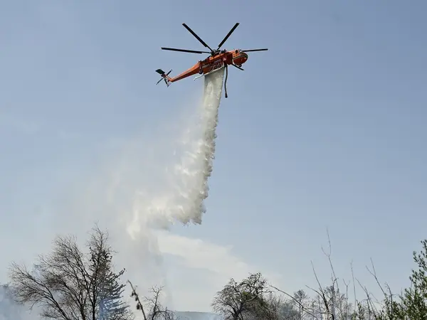 Ελικόπτερο εκτελεί ρίψεις σε πυρκαγιά